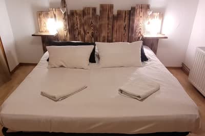 La chambre avec lit double, sous les combles lambrissés.